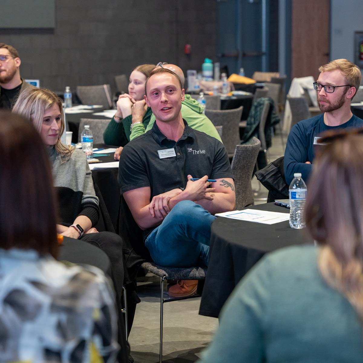 A group of event attendees converse together at their table.