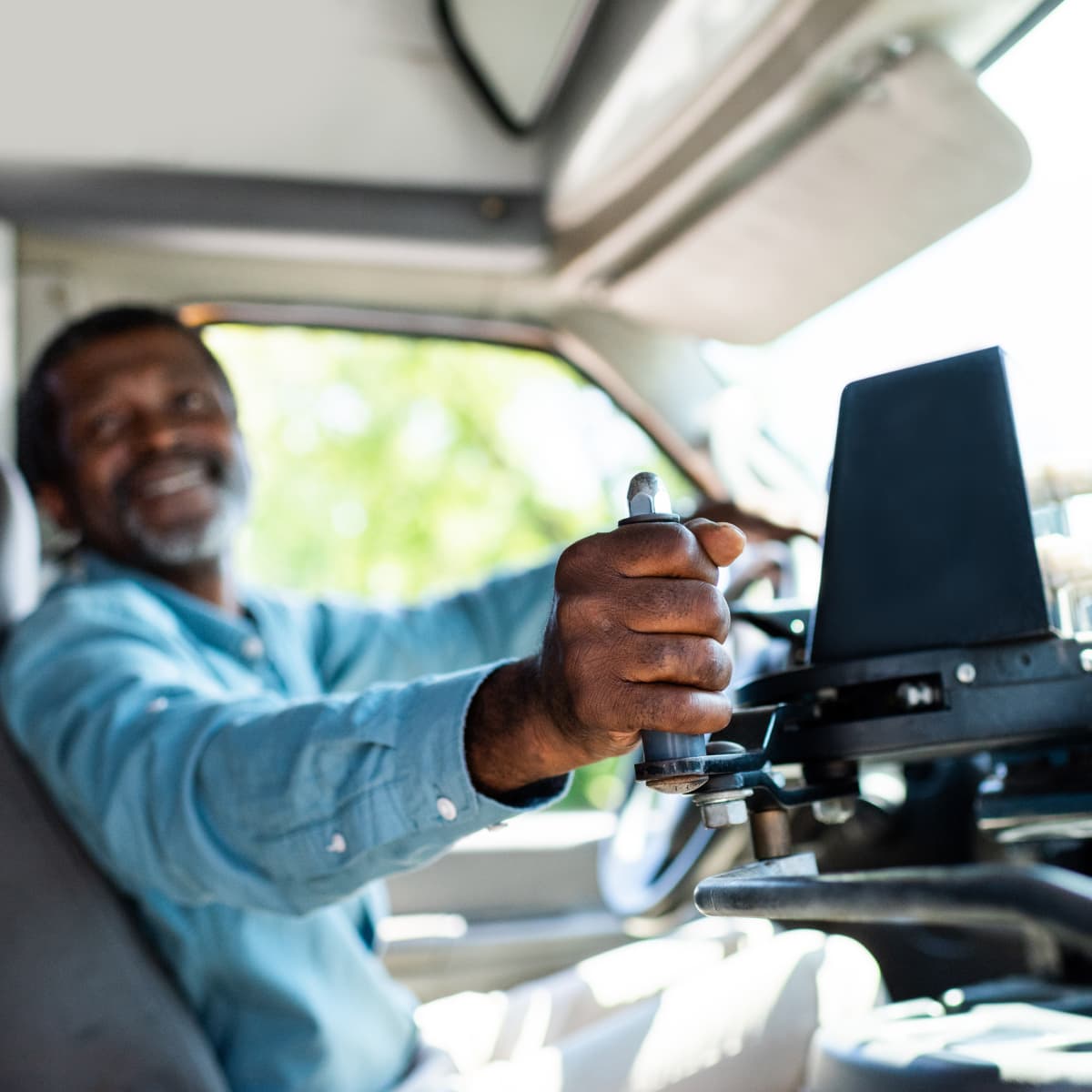 Bus driver smiling and letting resident aboard.