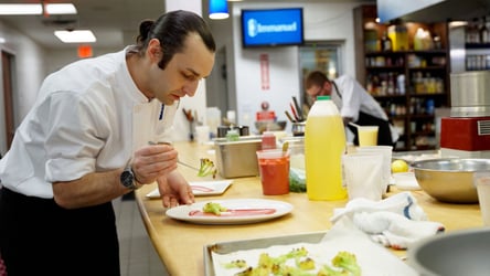 Chef plating food in an Immanuel kitchen