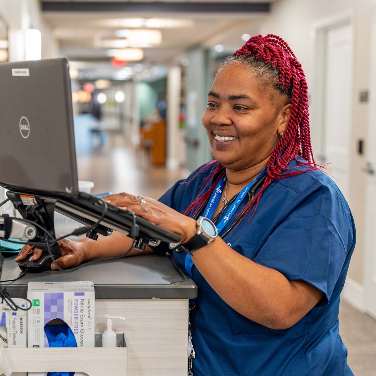 An Immanuel nurse works from her computer in a hallway.