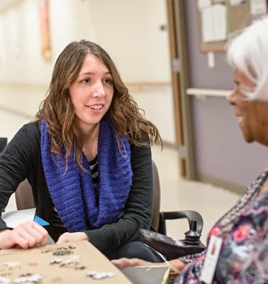An Immanuel Pathways employee works with a PACE® participant to complete a puzzle. 