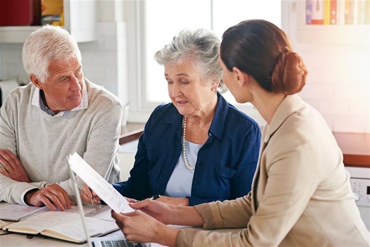 A senior couple goes over paperwork concerning their home sale.