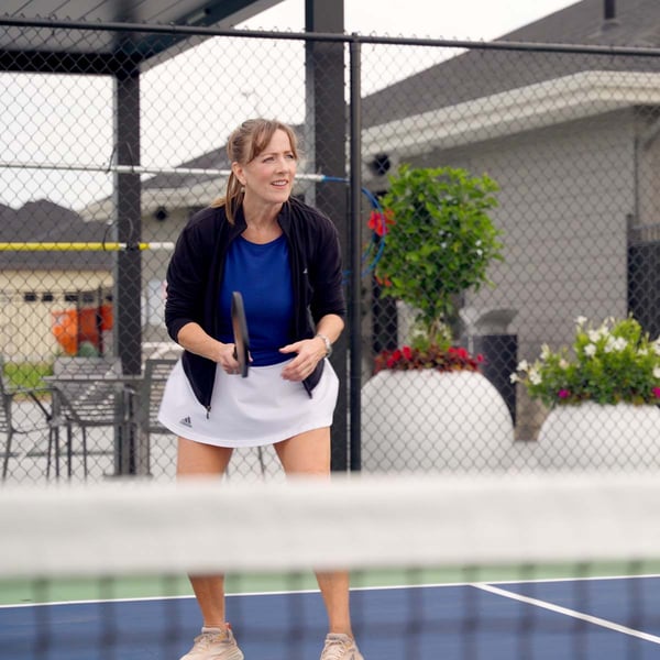 Woman smiling while playing pickleball.